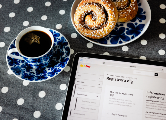 Kaffe, kanelbullar och surfplatta på ett prickigt bord