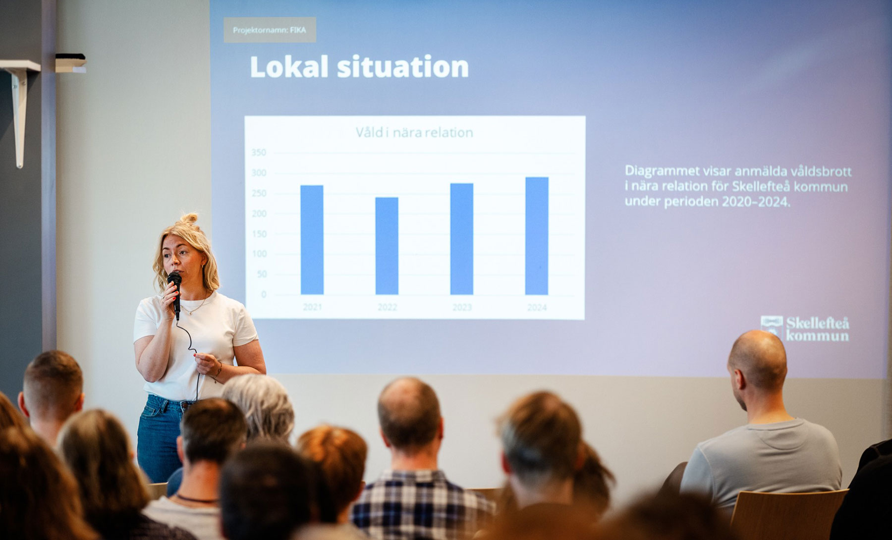 Kvinna föreläser för publik och visar bildspel