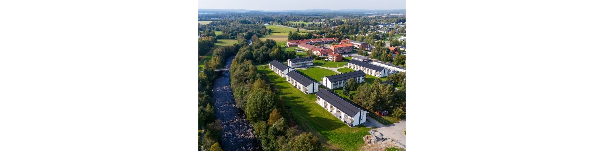 Vy över Kvarnbacken i Kåge med älven som rinner förbi